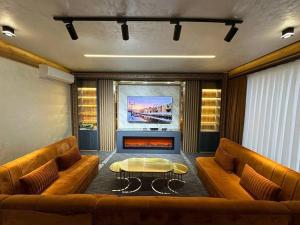 a room with two couches and a table and a fireplace at Villa Lux I in Chorwoq