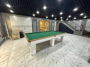 a pool table in a large room with stairs at Villa Lux I in Chorwoq +2 photos