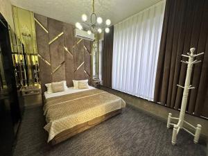a bedroom with a bed and a chandelier at Villa Lux I in Chorwoq