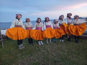 a group of women in orange skirts posing for a picture at Kantuta tours llachon in Llachon