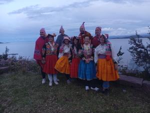 a group of people in traditional dress posing for a picture at Kantuta tours llachon in Llachon