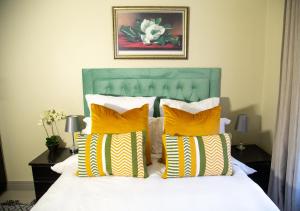 Un dormitorio con una cama con almohadas amarillas y blancas. en LUXE 25 On Eagle, en Vosburg