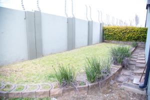 un jardín con una valla y un poco de hierba en LUXE 25 On Eagle, en Vosburg