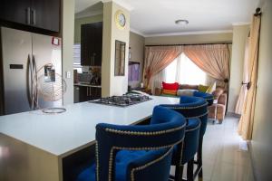 una cocina con una isla con sillas azules. en LUXE 25 On Eagle, en Vosburg