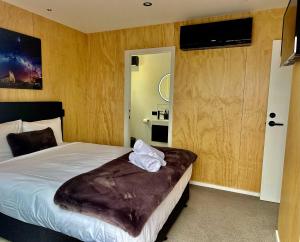 1 dormitorio con 1 cama con manta marrón en Rivers Edge Studio, en Lake Tekapo