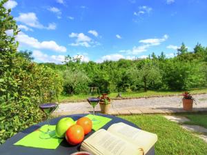 uma mesa com um livro e frutas e copos de vinho em Belvilla by OYO Holiday home with pool in Tuscany em Bucine