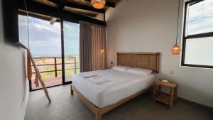 a bedroom with a bed with a view of a balcony at Villas Gratiam - Piscina Privada, Mar y Naturaleza en Vichayito in Los Órganos +60 photos