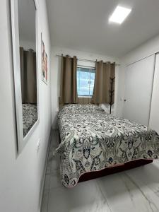 a bedroom with a bed and a mirror at Condominio HOME DUPLEX SERRA NEGRA in Bezerros