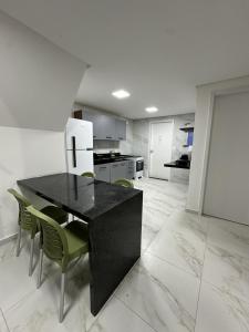 a kitchen with a black table and chairs at Condominio HOME DUPLEX SERRA NEGRA in Bezerros