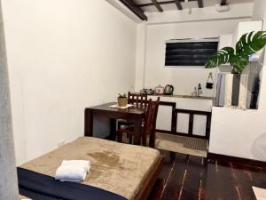 a living room with a table and a kitchen at Bayay ni Mamang Siargao - Ground Floor in General Luna