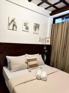 a bedroom with a bed with two towels on it at Bayay ni Mamang Siargao - Ground Floor in General Luna