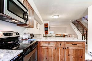 a kitchen with a stove and a microwave at Winter Point 22 in Breckenridge +16 photos