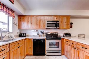 a kitchen with wooden cabinets and a stove top oven at Winter Point 22 in Breckenridge