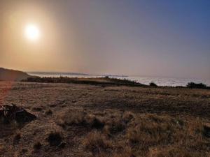 a beach with the sun setting over the water at Charming Retreat in Fontanales with Pool in Moya