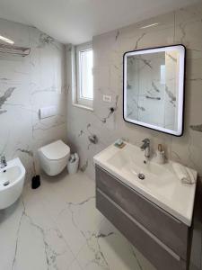 a white bathroom with a sink and a mirror at Holiday home in Punat - Insel Krk 54520 in Punat