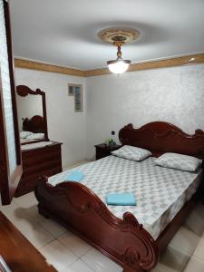 ein Schlafzimmer mit einem großen Holzbett und einem Spiegel in der Unterkunft شقة توجد وسط مدينة طنجة و تتوفر على كامل التجهيزات الضرورية خاصةبالعائلات in Tangier