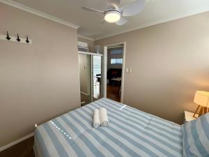 Un dormitorio con una cama con dos toallas encima. en The Beach Quarters, en Broadwater