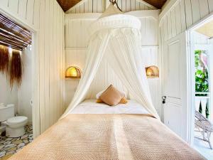 a bedroom with a bed with a mosquito net at Villa Stari in Canggu +47 photos