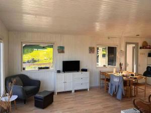 a living room with a couch and a table with a television at Cottage With A View- 5 Min From Beach in Allinge