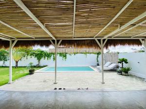 a pavilion with a swimming pool in a backyard at Villa Stari in Canggu