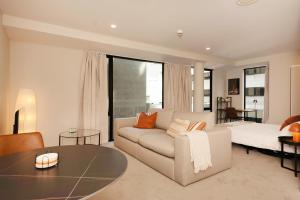 Brand New, Central & Spacious on Victoria Street في ويلينغتون: غرفة معيشة بها أريكة وطاولة