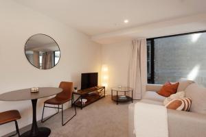 Brand New, Central & Spacious on Victoria Street في ويلينغتون: غرفة معيشة بها أريكة وطاولة