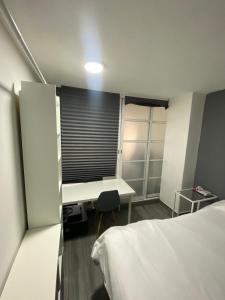 a room with two beds and a desk and a window at Charming Loft steps from the Angel in Cedro