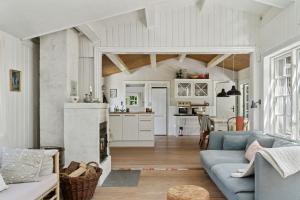 a living room with a blue couch and a kitchen at Beach And Forest Close To Tisvilde House in Tisvildeleje