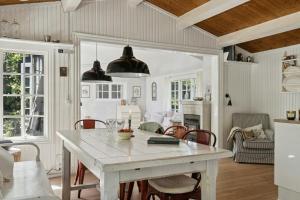 a kitchen and dining room with a white table and chairs at Beach And Forest Close To Tisvilde House in Tisvildeleje