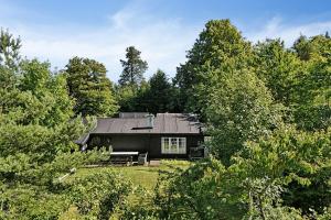 a black house in the middle of trees at Beach And Forest Close To Tisvilde House in Tisvildeleje +28 photos