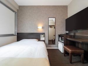 Postel nebo postele na pokoji v ubytování Super Hotel JR Shin-Osaka Higashiguchi