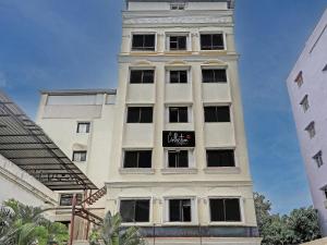 a tall white building with a sign on it at Super Townhouse Vaishnavi in Hyderabad