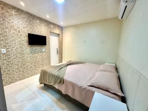 a bedroom with a bed and a tv on a wall at Casa Parque nacional Serra da capivara in Coronel José Diaz