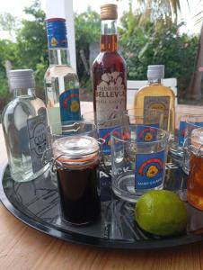 a tray with bottles and glasses of alcohol and a lime at Villa Ludger-Rose in Le Moule