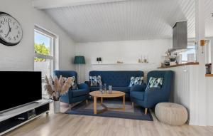 a living room with blue couches and a clock at Gorgeous Home In Sydals With Sauna in Neder Lysabild