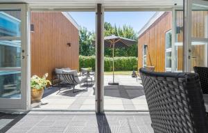 an open patio with chairs and an umbrella at Gorgeous Home In Sydals With Sauna in Neder Lysabild +16 photos