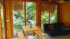 エル・ザイノにあるTiny Houses Unique Tayrona - Dentro del Parque Tayronaのテーブルと椅子と窓のある部屋