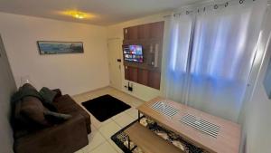 a living room with a couch and a coffee table at The Comfort Apt in Macaé