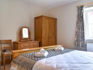 ein Schlafzimmer mit einem Bett, einer Kommode und einem Spiegel in der Unterkunft The Old Workshop in Keswick + 8 Fotos