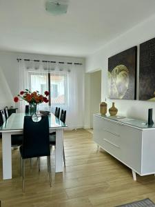 una sala da pranzo bianca con tavolo e sedie di Casa Ana a Nazaré