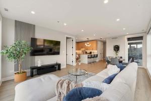 a living room with a white couch and a tv at New Build in Pilsen Spacious 2 Bed 2 Bath Unit in Chicago