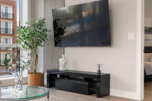 a living room with a glass table and a tv on a wall at New Build in Pilsen Spacious 2 Bed 2 Bath Unit in Chicago +33 photos