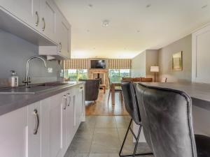 a kitchen with white cabinets and black chairs at Mayflower - Uk43632 in Grange