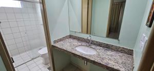 ein Badezimmer mit Waschbecken, Toilette und Spiegel in der Unterkunft Apartamento no Residencial Jardins das Thermas- Caldas Novas in Caldas Novas + 7 Fotos