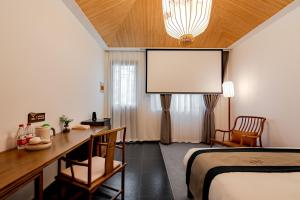 a hotel room with a bed and a projector screen at Yangzhou One or Two Mountain B&B in Yangzhou