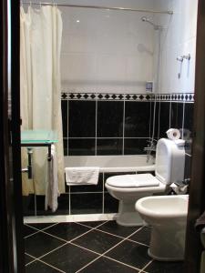 a bathroom with a toilet and a sink and a tub at Hotel Avenida Praia in Portimão