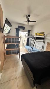 a bedroom with two bunk beds and a ceiling fan at Boulevard Center 1514 - 2 dormitórios - com piscina e sauna! in Guarujá