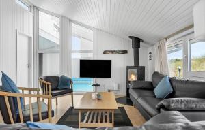 a living room with a couch and a tv at Holiday Home Bjerregårdsvej Hvide Sande Ds Denm in Bjerregård