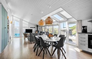 a kitchen and dining room with a table and chairs at Holiday Home Bjerregårdsvej Hvide Sande Ds Denm in Bjerregård