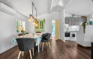 a kitchen and dining room with a table and chairs at Holiday Home Linningvej in Hemmet